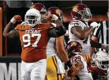  ?? Tim Warner / Getty Images ?? UT defensive lineman Chris Nelson, left, gets animated during a first-half stop on the goal line against USC on Saturday.