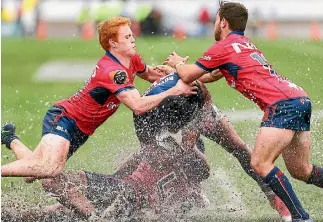 ?? GETTY IMAGES ?? The Tasman Makos’ intensity on defence is illustrate­d by Finlay Christie, left, and Mitch Hunt who combine with the lowtacklin­g Pari Pari Parkinson to bring Aucklander Melani Nanai to ground on a water-logged Trafalgar Park.