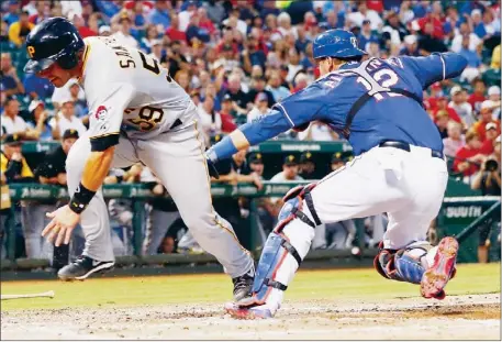  ?? Tom Pennington/Getty Images photos ?? Tony Sanchez stumbles as he passes Texas catcher A.J. Pierzynski but still manages to score in the third inning Tuesday night in Arlington, Texas, to give the Pirates a 1-0 lead against the Texas Rangers.