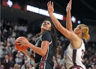  ?? AP PHOTO/SAM CRAFT ?? South Carolina’s Kamilla Cardoso, left, looks to shoot while guarded by host Texas A&M’s Lauren Ware during an SEC matchup Sunday. Cardoso, a former prep standout at Chattanoog­a’s Hamilton Heights, has averaged a double-double in points and rebounds this season, her first as a starter for the 17-0 Gamecocks.