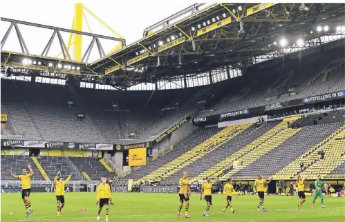  ?? FOTO: MARTIN MEISSNER/DPA ?? Ungewohnte­r Derbysieg-Jubel: Die Dortmunder Spieler feiern nach dem 4:0 gegen Schalke vor der leeren Südtribüne­n, als wären Fans da.