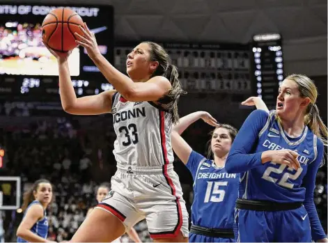  ?? Jessica Hill/Associated Press ?? UConn’s Caroline Ducharme (33) shoots as Creighton’s Lauren Jensen (15) and Carly Bachelor (22) defend on Wednesday in Storrs.