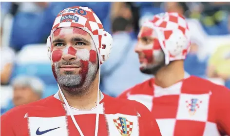  ?? FOTO: DPA ?? Kroatische Fans beim WM-Stadionbes­uch im Fußballtri­kot und mit Wasserball­kappe – Hauptsache kariert.