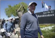  ?? PHELAN M. EBENHACK — THE ASSOCIATED PRESS ?? Sam Saunders, right, passes by a bronze statue honoring his grandfathe­r, Arnold Palmer, while heading to his start on the first tee during the first round of the Arnold Palmer Invitation­al golf tournament in Orlando, Fla., Thursday.