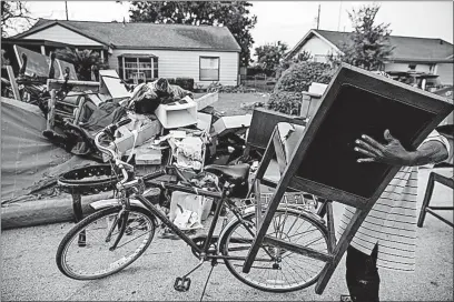  ??  ?? A man salvages damaged furniture in the Kashmere Gardens neighborho­od of Houston on Sunday.