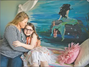  ??  ?? Mary Jane poses with her grandmothe­r Linda Soli at her home. “My favorite thing is the mermaid picture on the wall because it’s a mermaid and I love it,” Mary Jane said. “It’s shiny and bright.”