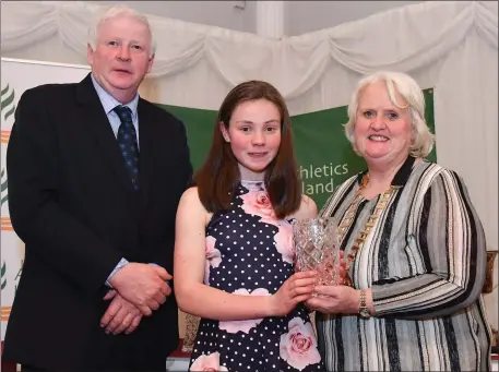  ??  ?? Niamh O’Mahony of An Ríocht AC, is presented her Star Award trophy by Chairperso­n of the Athletics Ireland Juvenile Committee John McGrath and President of Athletics Ireland Georgina Drumm during the Juvenile Star Awards 2019 at The Bridge Hotel in Tullamore, Offaly. Photo by Sportsfile