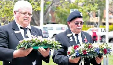  ??  ?? Ferdie Hedder and Rory Russouw lay wreathes at the cenotaph in Empangeni