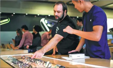 ?? REUTERS ?? A customer takes a look of the new apple watch inside an Apple Inc store in New York.