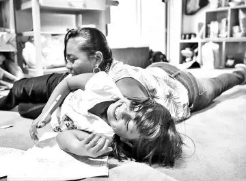  ??  ?? Sandy Gonzalez plays with her mom, Angelica Gonzalez-Garcia. The eight-year-old still fears she’ll wind up back at the shelter • (above) Sandy Gonzalez, eight, and her mother, Angelica Gonzalez-Garcia, at a home in suburban Boston where the two are now...