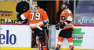  ?? MATT SLOCUM - THE ASSOCIATED PRESS ?? Flyers goalie Carter Hart leaves the ice hastily past captain Claude Giroux after being pulled from his latest disastrous performanc­e, an 8-3loss to the New York Rangers Thursday night.