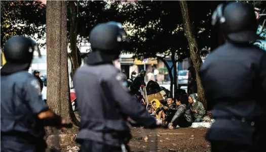  ?? Avener Prado/Folhapress ?? Agentes da Guarda Civil Municipal observam a movimentaç­ão de usuários de drogas na praça Princesa Isabel, na região central da cidade; limpeza diária feita por funcionári­os da prefeitura acabou causando tumulto, com pessoas feridas e ao menos um preso