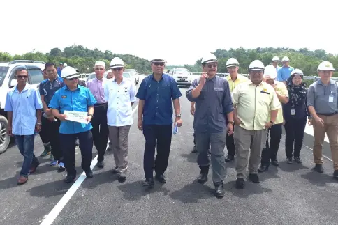  ??  ?? Julaihi (fourth left), flanked by Dr Hazland on his left and Ismail, together with JKR staff walk on the almost completed bridge.