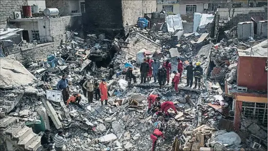  ?? FELIPE DANA / AP ?? Bomberos y miembros de la defensa civil iraquí buscando cadáveres entre las ruinas en el barrio de Al Yadida, el pasado 24 de marzo