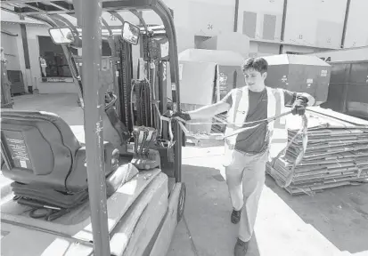  ?? RICH POPE/ORLANDO SENTINEL ?? Luis Diaz, 20, works at the Goodwill Industries of Central Florida warehouse loading docks in Taft on Thursday. Diaz is pursuing a degree in forensic psychology at the University of Central Florida and is using the Goodwill prepaid tuition program to cover the cost.