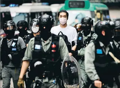  ?? ANTHONY WALLACE / AFP ?? La policía se lleva detenido a un joven manifestan­te en el centro de Hong Kong