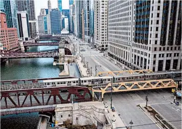  ?? ZBIGNIEW BZDAK/CHICAGO TRIBUNE ?? A train crosses an empty intersecti­on at the Chicago River on March 24. City streets all over the nation have gone quiet as citizens self-quarantine. Talk to your children about what “normal” means now, and how it will change.