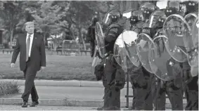  ?? PATRICK SEMANSKY/AP ?? President Donald Trump walks past police in Lafayette Park after he visited St. John’s Church near the White House on June 1.