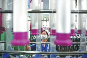  ?? XINHUA ?? A worker operates a machine at a textile company in Baoji, Shannxi province.