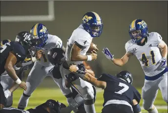  ?? (NWA Democrat-Gazette/Charlie Kaijo) ?? North Little Rock quarterbac­k Kareame Cotton (center) carries the ball against Springdale Har-Ber.