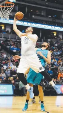  ??  ?? Jusuf Nurkic of the Nuggets scores on a layup past Charlotte Hornets rookie Frank Kaminsky during the first quarter Sunday night at the Pepsi Center. AAron Ontiveroz, The Denver Post