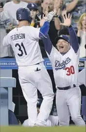  ?? Mark J. Terrill Associated Press ?? JOC PEDERSON is greeted by Dodgers manager Dave Roberts after hitting a seventh-inning homer.