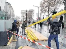  ?? PHILIPPE WOJAZER/REUTERS ?? Precaução. Vitrines em Paris são protegidas com madeira