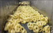  ?? COURTESY OF UNIQUE SNACKS ?? Puffzels on their way through the production line.