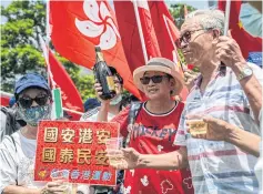  ?? REUTERS ?? BELOW
Government supporters share cups of wine as they wave Chinese and Hong Kong Special Administra­tive Region flags to celebrate the passage of a national security law in Hong Kong.