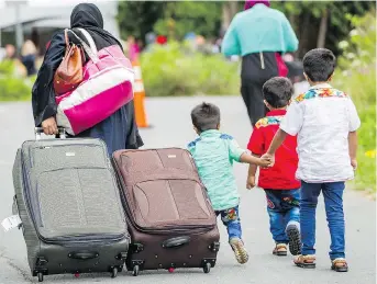  ?? GEOFF ROBINS/AFP/GETTY IMAGES ?? Asylum seekers walk toward the Canada-U.S. border near Champlain, N.Y. Most immigrants to Canada choose the country because they appreciate Canadian values, writes Rajesh Shukla.