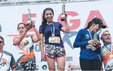  ??  ?? Una de las campeonas de ELGA Run muestra con mucho orgullo su medalla y trofeo que la acreditan como vencedora.