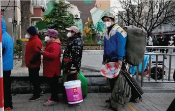  ?? — AFP photo ?? People wait in a long queue to be tested for Covid-19 coronaviru­s at an open nucleic acid testing site as many testing stations are shut down in Beijing.