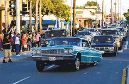  ?? NELVIN C. CEPEDA U-T ?? Customized lowriders cruise down Highland Avenue in National City on Friday. The event celebrates the temporary return of legal cruising to the thoroughfa­re. More than 100 classic cars took part in the Friday night lowrider cruise.