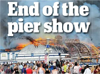  ??  ?? Fire-ravaged: A crowd gathers as Eastbourne Pier goes up in flames in 2014