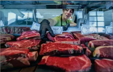  ?? PHOTOS BY TERRY PIERSON — STAFF PHOTOGRAPH­ER ?? Butcher Dessa D’Aquila-Bentson stocks meat in the display at Graze and Gather Meats in Claremont on Feb. 17. Graze and Gather celebrated its one-year anniversar­y in December. The owners plan to expand the shop’s class offerings.