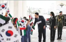  ?? WAM ?? President Yoon greets children waving UAE and South Korean flags following his arrival at Qasr Al Watan. He said people-to-people contact forms the basis of bilateral ties. ■