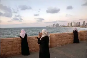  ?? The Associated Press ?? MEDITERRAN­EAN SEA: Israeli Arab women look out over the Mediterran­ean sea on Sept. 23 in the mixed Arab Jewish city of Jaffa, near Tel Aviv, Israel.