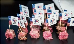  ??  ?? Back on the market: US flags and branding are seen on US beef samples during a promotiona­l event in Beijing. China opened its gates to US beef imports earlier this year after a 14-year ban. — AFP