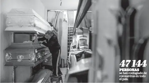  ?? FOTO: AFP ?? > Dueño de una funeraria prepara los ataúdes de su tienda.