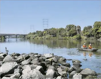  ?? Brian van der Brug Los Angeles Times ?? L.A. COUNTY WORKERS collect trash in the San Gabriel River near Seal Beach last week. The green sea turtles have to navigate through garbage, discarded shopping carts, tires, plastic bottles and other debris.