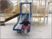  ?? EVAN BRANDT — MEDIANEWS GROUP ?? Laura Spiece, 6, clears the snow off the slide at Rupert Elementary School as she and her brother Sid played in the snow during the start of Wednesday’s snowstorm.