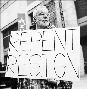  ?? PATRICK SEMANSKY THE ASSOCIATED PRESS ?? John McKeon holds a sign as he protests outside of a hotel hosting the United States Conference of Catholic Bishops' annual fall meeting on Monday in Baltimore.