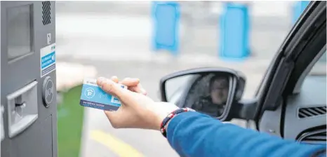  ?? FOTO: TOM WELLER/DPA ?? Eine Parkkarte wird an einem Parkplatz an eine Schranke gehalten: Mehrere Anbieter arbeiten daran, dass dies künftig auch digital funktionie­rt.