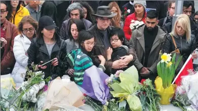  ?? GEOFF ROBINS / AGENCE FRANCE-PRESSE ?? Mourners attend a makeshift memorial on Tuesday, a day after a van struck multiple people along a major intersecti­on in Toronto.