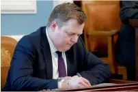  ?? AP ?? Iceland’s Prime Minister Sigmundur David Gunnlaugss­on, writes during a parliament­ary session in Reykjavik on Monday. Gunnlaugss­on resigned on Tuesday under pressure by people after being linked to an offshore company. —