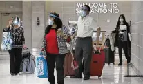  ?? Bob Owen / Staff file photo ?? Travelers wearing face masks and face shields arrive at San Antonio Internatio­nal Airport before Thanksgivi­ng.