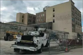  ?? RICHARD PAYERCHIN — THE MORNING JOURNAL ?? Trucks and equipment are parked outside the Broadway Building Oct. 23 as workers rebuild a parking garage there. The city and Lorain Port Authority created a new district to help finance renovation of the hotel and eventually lead to money savings for other businesses.