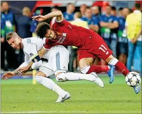  ??  ?? Sergio Ramos trekt Mohamed Salah naar de grond, waarna de Egyptenaar geblesseer­d raakt.
(Foto: ESPN)