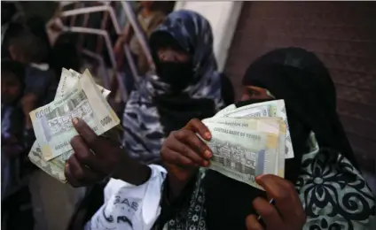  ??  ?? In this Nov. 14, 2015 file photo, women display paper currency after receiving cash support from UNICEF, in Sanaa, Yemen. Saudi Arabia’s King Salman has ordered the transfer of $2 billion to Yemen, a day after the war-torn country’s Saudi-backed prime...