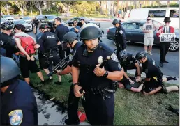  ?? LUIS SINCO/LOS ANGELES TIMES ?? Beverly Hills police officers break up a scuffle between pro- and anti-Trump protesters gathered at the intersecti­on of Sunset Boulevard and Benedict Canyon Road in Beverly Hills on Tuesday. As protesters clashed, President Donald Trump attended a fundraiser nearby at the home of real estate developer Geoff Palmers.